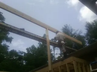 Carpenter setting a ridge beam over a new addition frame — Ice Dam Removal by Roofing Brothers in West Barnstable