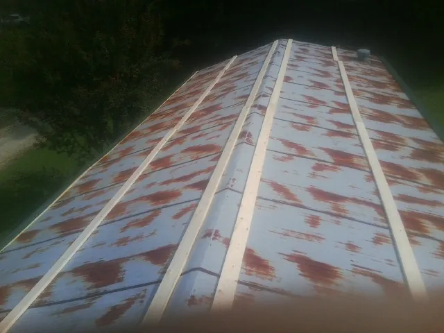 Rusted metal roof panels with new wood purlins before replacement — Storm Damage Roof Repair in West Barnstable by Roofing Brothers