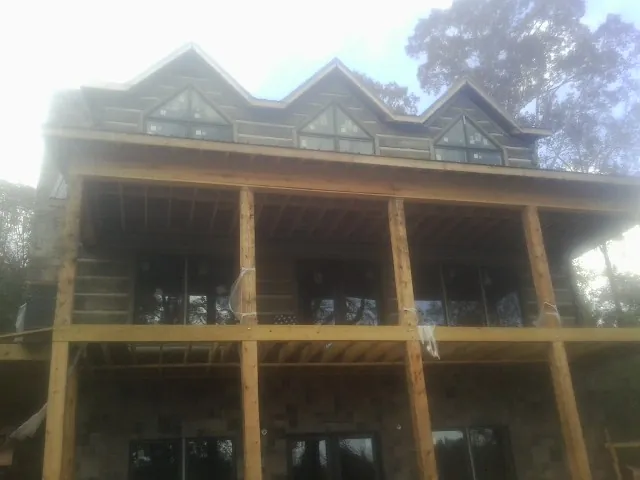 Dormers and porch framing on a large log home under construction — Roof Coating work by our crew in West Barnstable