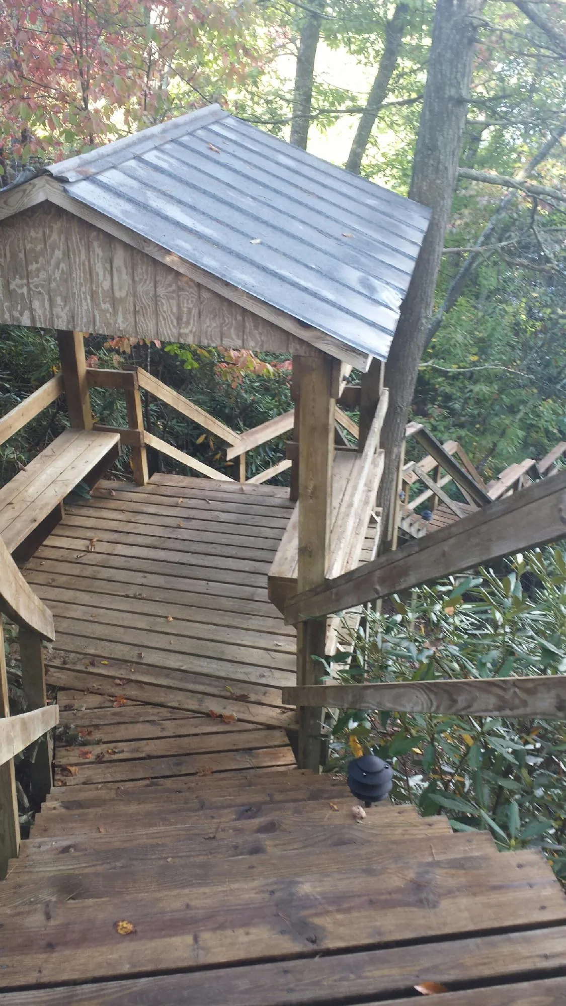 Metal roofed shelter over wooden steps on a wooded walkway — Skylight Repair & Installation work by our crew in West Barnstable
